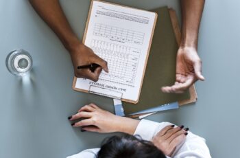 Aerial view of doctor writing patient daily report checklist