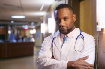 A portrait of an African-American doctor in a hospital under the lights with a blurry background